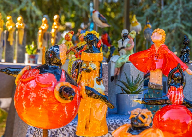 Glazige keramiek met felle kleuren rood, oranje en blauw wat een heel gezellig en warm sfeerbeeld schept.
